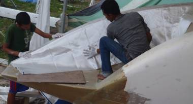 Beng and Baw laying a second skin of glass on the port wall