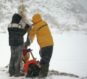 Bianca & Thupten string prayer flags in a blizzard