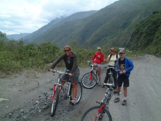 Ride on! Kids on bikes on a wet, graveled road with gorgeous views