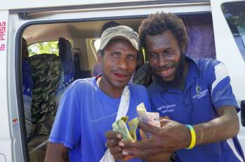 Bus helper hams it up with fistful of Kina, PNG