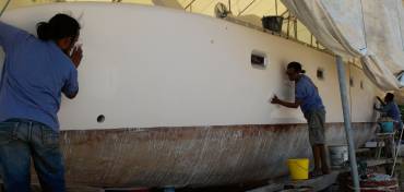 Chai, Lek & Yoong wet-sanding the starboard topsides with 600