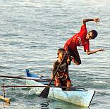 Papuan boys jump from canoe.