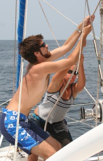 Chris & Amanda haul up the mainsail together.