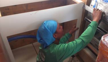 Houa working on the sink cabinet in the galley