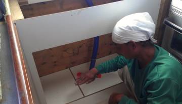 Houa working on the sink cabinet in our tiny galley