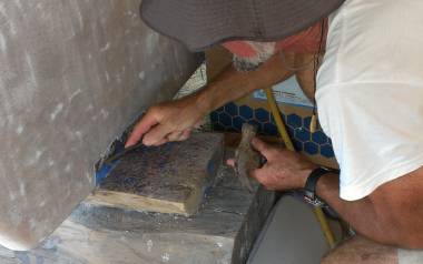 Jon chiseling off old antifouling paint from around the supports