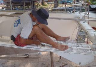 Jon balances on anchor/chain strut to remove rollers