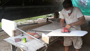 Jon sanding the white epoxy primer on the rudders smooth