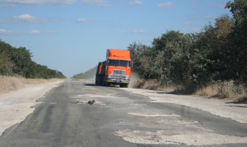 Potholes in Botswana force even big trucks off road.