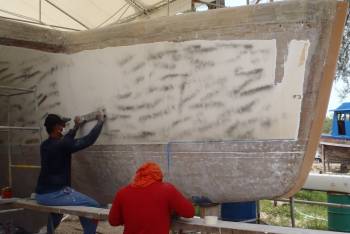 Long-boarders working on the insides of the hulls