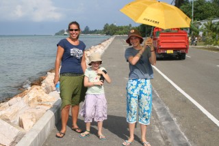 Walking the one paved street on Feydoo beside the lagoon with Abby and Eliza