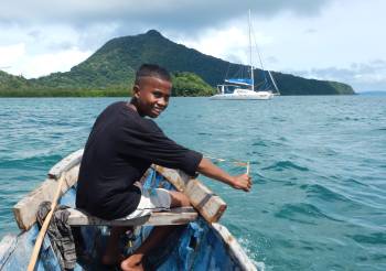 Riding in a local boat with boy with slingshot