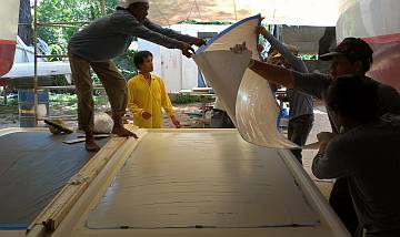 Receiving the big, gooped up sheet of nonskid for the bimini