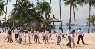 Kids on a Singapore beach. The harbor behind.