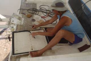Sue removes the old flat gasket from a hatch cover