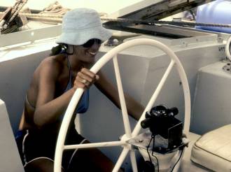 Sue on Sabi Star's huge helm, in the tropics